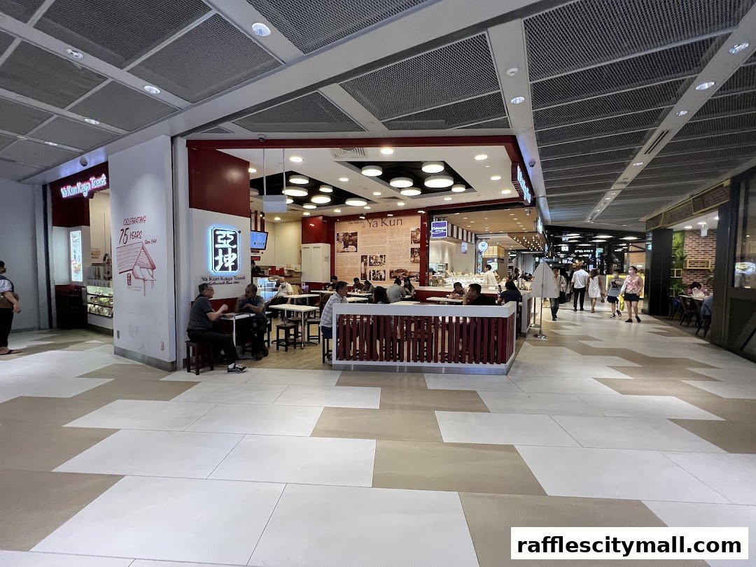 A busy Ya Kun Kaya Toast cafe with customers dining inside and people walking by in the mall.