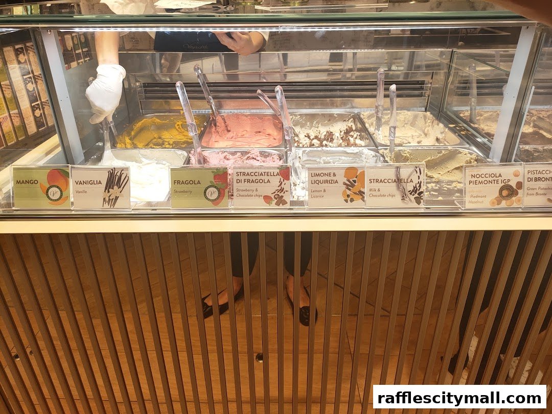A display case filled with various flavors of gelato, with labels indicating the flavors.